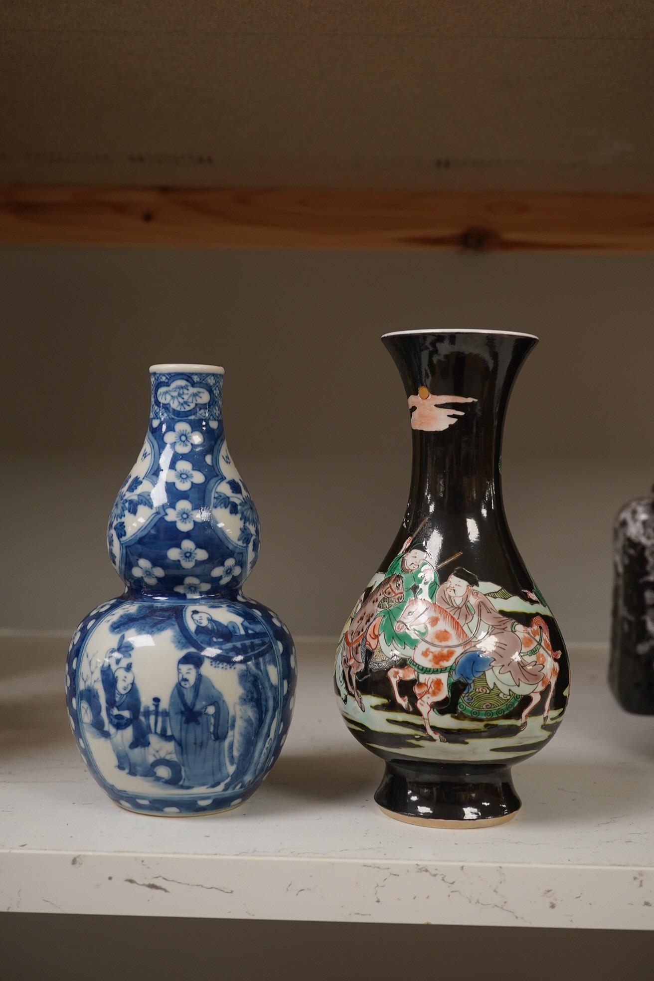 Two Chinese vases; a blue and white double gourd vase and famille noir vase, famille noir 19cm high. Condition - good